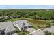 Aerial view of home with a gray roof, a pond, a stone facade, and a well manicured lawn at 7765 Grande Shores Dr, Sarasota, FL 34240