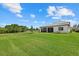 Expansive green backyard featuring a covered patio, lush lawn, and scenic landscaping, providing a serene outdoor space at 7765 Grande Shores Dr, Sarasota, FL 34240