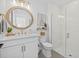 Updated bathroom features a circular mirror, gold hardware, and a glass walk-in shower at 7765 Grande Shores Dr, Sarasota, FL 34240