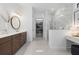 Bathroom features a double vanity, round mirrors, and walk-in shower with marble-look tile at 7765 Grande Shores Dr, Sarasota, FL 34240