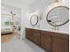 Bathroom features a double vanity with round mirrors, quartz counters, and an open bedroom view at 7765 Grande Shores Dr, Sarasota, FL 34240