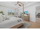 Bright bedroom features a wood canopy bed, neutral decor, ceiling fan, and natural light at 7765 Grande Shores Dr, Sarasota, FL 34240