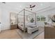 Bright bedroom features a wood canopy bed, neutral decor, ceiling fan, and natural light at 7765 Grande Shores Dr, Sarasota, FL 34240