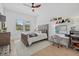 Cozy bedroom features a ceiling fan, a window with plantation shutters and a gray color palette at 7765 Grande Shores Dr, Sarasota, FL 34240