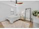 Bright bedroom featuring a ceiling fan, plush rug, and a full-length mirror reflecting the doorway at 7765 Grande Shores Dr, Sarasota, FL 34240