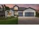 Charming home with gray roof, stone accents, a beautiful lawn, and a two car garage at 7765 Grande Shores Dr, Sarasota, FL 34240