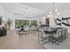 Open concept living room and dining area with coffered ceilings, hardwood floors and large windows at 7765 Grande Shores Dr, Sarasota, FL 34240