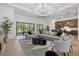 Spacious living room featuring a modern chandelier, large windows, and an open layout to the kitchen at 7765 Grande Shores Dr, Sarasota, FL 34240