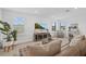 Cozy living room features a large flatscreen tv, natural lighting with plantation shutters and neutral decor at 7765 Grande Shores Dr, Sarasota, FL 34240