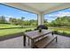 Outdoor dining area with a wooden table, and views of the lush backyard and a pond at 7765 Grande Shores Dr, Sarasota, FL 34240