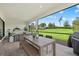 Inviting outdoor seating area overlooking the yard, featuring a wooden table, chairs, and a beautiful view at 7765 Grande Shores Dr, Sarasota, FL 34240