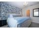 Charming bedroom with blue floral wallpaper accent wall, chandelier, and ample natural light at 8232 Reefbay Cv, Parrish, FL 34219