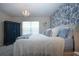 Elegant bedroom with blue floral wallpaper, soft carpet, and a chandelier at 8232 Reefbay Cv, Parrish, FL 34219