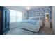 Cozy bedroom with blue floral wallpaper accent wall and a beautiful chandelier at 8232 Reefbay Cv, Parrish, FL 34219