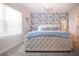 Comfortable bedroom with blue floral wallpaper accent wall and a sunny window at 8232 Reefbay Cv, Parrish, FL 34219