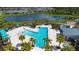 Aerial view of the community pool featuring lounge chairs and tropical palms at 8232 Reefbay Cv, Parrish, FL 34219