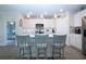 Modern kitchen with a central island, white cabinets, and stylish bar stools at 8232 Reefbay Cv, Parrish, FL 34219
