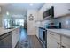 View of kitchen with stainless appliances and living and dining area views at 8232 Reefbay Cv, Parrish, FL 34219