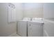 Well-lit laundry room featuring a white washer and dryer, plus convenient shelving at 8232 Reefbay Cv, Parrish, FL 34219
