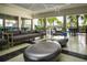 A community lounge features modern seating, decorative tables, and a view of the lush tropical landscaping at 8232 Reefbay Cv, Parrish, FL 34219