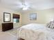 Cozy bedroom featuring a queen bed, dresser, stylish mirror and neutral décor at 892 Country Club Cir # 50, Venice, FL 34293