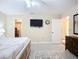 This bedroom features a ceiling fan, mounted TV, adjacent doors and neutral décor at 892 Country Club Cir # 50, Venice, FL 34293