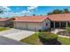 Charming single-story villa with a tile roof, attached garage and walkway leading to the covered screened porch at 892 Country Club Cir # 50, Venice, FL 34293
