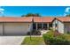 Charming single-story villa with a tile roof, attached garage and walkway leading to the covered screened porch at 892 Country Club Cir # 50, Venice, FL 34293