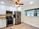 Bright kitchen with stainless steel appliances, white cabinets, and wood-look tile flooring at 892 Country Club Cir # 50, Venice, FL 34293