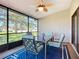 Enclosed lanai featuring a ceiling fan, screened windows, neutral walls, and dining furniture at 892 Country Club Cir # 50, Venice, FL 34293