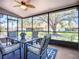 Enclosed lanai with a ceiling fan, dining table set, screened windows, and a peaceful outdoor view at 892 Country Club Cir # 50, Venice, FL 34293