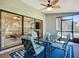 An enclosed lanai with sliding glass doors to the home and screens to the outside and dining furniture at 892 Country Club Cir # 50, Venice, FL 34293
