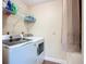 The laundry area features a washer, dryer, wire shelving, and white walls at 892 Country Club Cir # 50, Venice, FL 34293