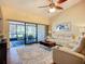 Open-plan living room with lots of natural light, ceiling fan, and sliding glass doors to the porch at 892 Country Club Cir # 50, Venice, FL 34293