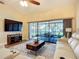 The comfy living room boasts tile floors, a large screened sliding glass door and modern furniture at 892 Country Club Cir # 50, Venice, FL 34293