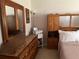Well-lit bedroom with a matching wood dresser, nightstand, and armoire creating a cohesive design at 900 La Costa Cir # 4, Sarasota, FL 34237