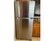 Stainless steel refrigerator with top freezer, complemented by wood cabinets and granite countertops at 900 La Costa Cir # 4, Sarasota, FL 34237