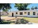 An open backyard with a brick and stone fire pit area, and well-maintained lawn at 1028 36Th E Ave, Ellenton, FL 34222