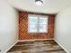 Unique bedroom featuring a brick accent wall, natural light, and modern flooring at 1028 36Th E Ave, Ellenton, FL 34222