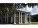 Two-story home with white columns, a front balcony, and landscaped grounds at 1028 36Th E Ave, Ellenton, FL 34222