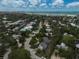 Picturesque aerial view of a coastal neighborhood with lush greenery, leading to the white sand beach and turquoise ocean at 105 Island Cir, Sarasota, FL 34242