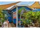 Exterior of a vibrant blue restaurant with tropical decor, plants, and outdoor seating at 105 Island Cir, Sarasota, FL 34242