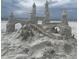 Impressive sand castle sculpture with detailed turrets, arches, and stairs on the beach, showcasing artistic creation at 105 Island Cir, Sarasota, FL 34242