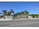 Street view of Siesta Beach entrance with manicured landscaping, palm trees, and clear signage under a blue sky at 105 Island Cir, Sarasota, FL 34242