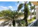 Balcony with lush tropical trees and a street view under a sunny sky at 1064 N Tamiami Trl # 1133, Sarasota, FL 34236