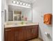 Bathroom with double sinks, wood cabinets, and shower at 1064 N Tamiami Trl # 1133, Sarasota, FL 34236