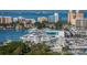 Picturesque marina view featuring a variety of yachts, waterfront condos, and lush trees under a clear blue sky at 1064 N Tamiami Trl # 1133, Sarasota, FL 34236