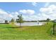 Picturesque backyard with a peaceful lake view, mature trees, and vibrant green lawn stretching to the water's edge at 12570 Brookgreen St, Venice, FL 34293