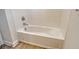 Clean white tub/shower with modern fixtures and wood-look tile flooring at 12570 Brookgreen St, Venice, FL 34293