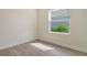 Bright bedroom featuring a window, neutral walls, and wood-look flooring at 12570 Brookgreen St, Venice, FL 34293